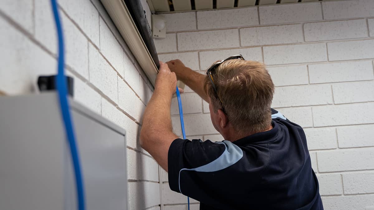 Air con expert removing an aircon unit from the wall